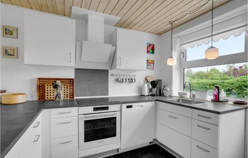 a kitchen with white cabinets and a sink and a window at 3 Bedroom Pet Friendly Home In Hejls in Hejls