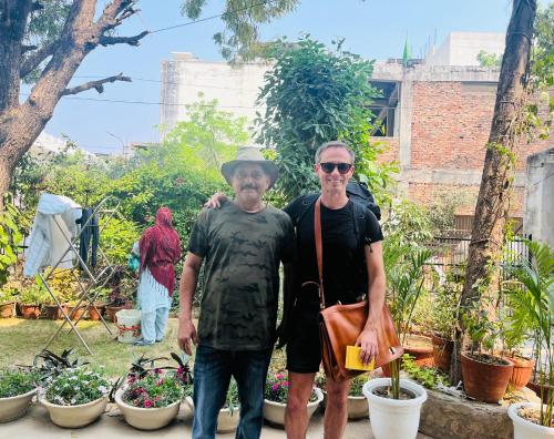 two men standing in front of a garden at Alibaba’s Indiana Homestay in Agra