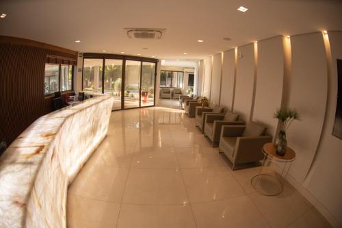 a lobby of a hotel with couches and chairs at Hotel Capital Das Pedras in Teófilo Otoni