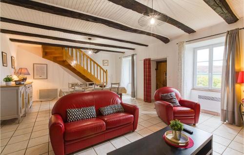 a living room with two red chairs and a table at Cozy Home In Pierrefiche With Wifi in Pierrefiche