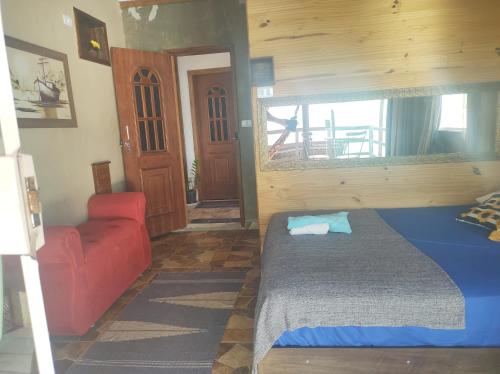 a bedroom with a bed and a red couch at Pousada Marambaia Café in Barra de Guaratiba