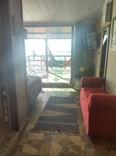 a living room with a couch and a view of a patio at Pousada Marambaia Café in Barra de Guaratiba