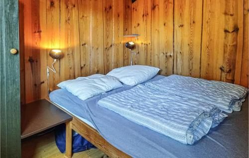 łóżko w pokoju z drewnianymi ścianami w obiekcie Nice Home In Anholt With Kitchen w mieście Anholt