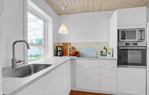 a white kitchen with a sink and a microwave at Gorgeous Home In Vestervig With Wifi in Vestervig