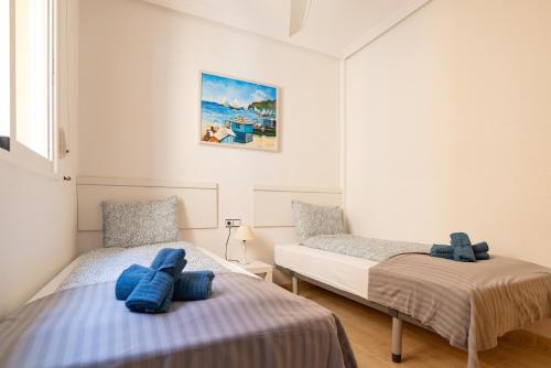 a bedroom with two beds and a painting on the wall at Casa Gris in Orihuela Costa