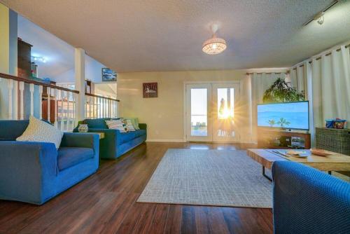 a living room with blue couches and a flat screen tv at Paradise Waterfront Cottage (35 Min Drive From Toronto) in Georgina