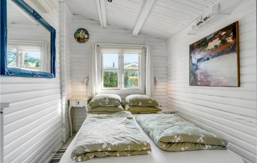 2 Betten in einem Zimmer mit weißen Wänden und Fenstern in der Unterkunft 1 Bedroom Awesome Home In Bog By in Bogø By