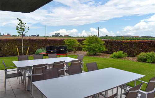 a patio with white tables and chairs and a grill at 4 Bedroom Awesome Home In Langemark in Langemark