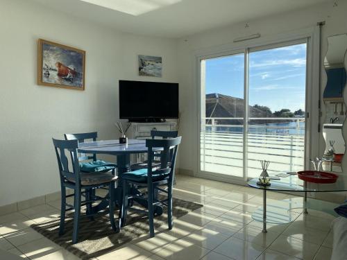 une salle à manger avec une table et des chaises et une grande fenêtre dans l'établissement Appartement 1 pièce 35m² - Centre Étel - Vue port - 3 pers. - FR-1-397-51, à Étel