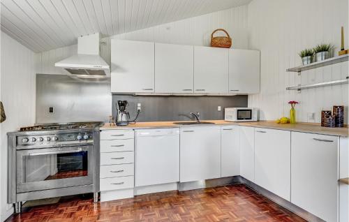 a white kitchen with white cabinets and a stove at Beautiful Home In Ebeltoft With Wifi in Ebeltoft