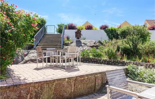 a patio with a table and chairs in a garden at Cozy Apartment In Gudhjem With Wifi in Gudhjem