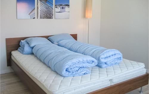 a bed with blue pillows on top of it at Beautiful Apartment In Gudhjem With 1 Bedrooms, Wifi And Outdoor Swimming Pool in Gudhjem