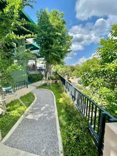 a walkway in front of a house with a fence at Family Room by 233Poshtel in Lampang