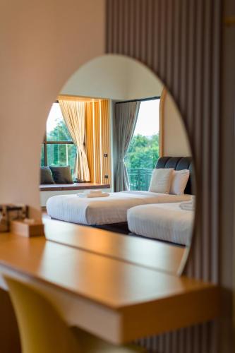 two beds in a hotel room with a window at Family Room by 233Poshtel in Lampang