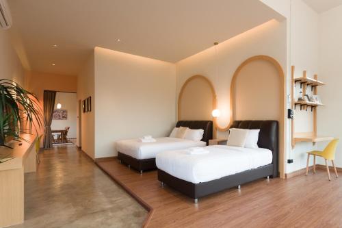 duas camas num quarto com duas janelas em Family Room by 233Poshtel em Lampang