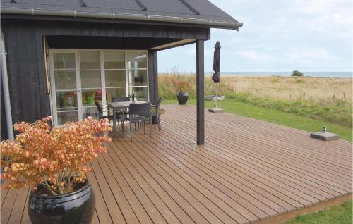 una terrazza in legno con tavolo e sedie su una casa di Awesome Home In Nysted With Sauna a Nysted