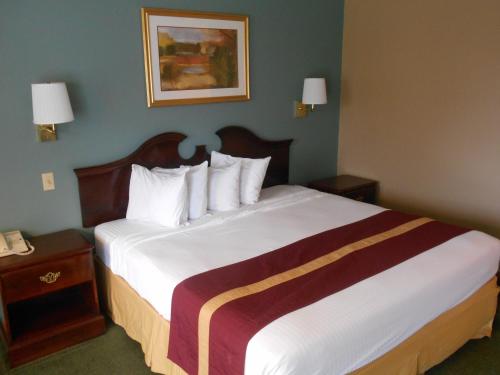 a hotel room with a large bed with white sheets at SureStay by Best Western Cameron in Cameron