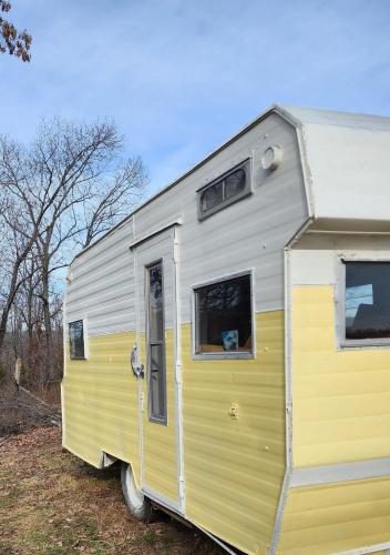 een gele en witte trailer met een hond in een raam bij Goin' Bonanza Glamping Ranch in Mammoth Spring