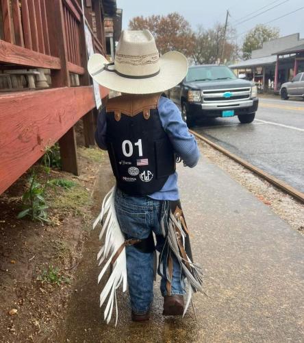 Un bambino con un cappello da cowboy che cammina per strada di Goin' Bonanza Glamping Ranch a Mammoth Spring