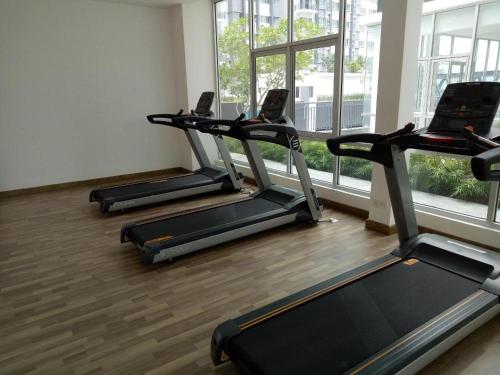 three treadmills in a gym with a large window at QAISARA D'SAVANNA HOMESTAY@SOUTHVILLE CITY in Bangi