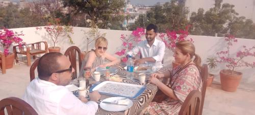 a group of people sitting around a table at Alibaba’s Indiana Homestay in Agra