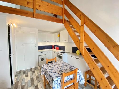 une cuisine avec une table et un escalier dans l'établissement Appartement cosy 4 pers. avec loggia 100m de la mer - 1ère ligne, parking inclus, Bretignolles-sur-Mer - FR-1-231-283, à Bretignolles-sur-Mer