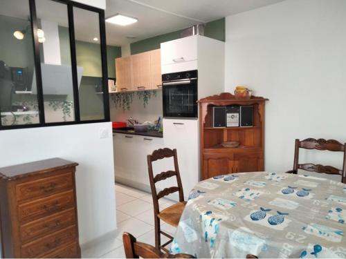 une cuisine avec une table et une salle à manger dans l'établissement Maison rénovée T3 au calme, proche plage, marché et commodités, avec cour et Wifi inclus - FR-1-331-222, à Les Sables-dʼOlonne