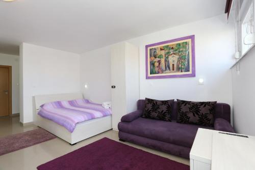 ein Wohnzimmer mit einem Sofa und einem Bett in der Unterkunft Luxury Town Center Apartments in Zadar