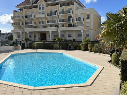 une piscine devant un immeuble dans l'établissement Appartement avec Piscine et Parking, 2 Pièces à Port-Guillaume - FR-1-487-347, à Dives-sur-Mer