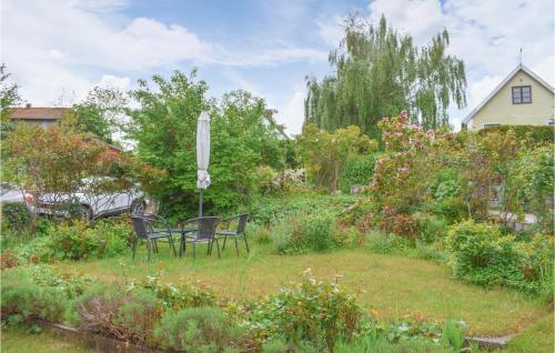a garden with chairs and flowers in a yard at Stunning Home In Simrishamn With Wifi in Simrishamn