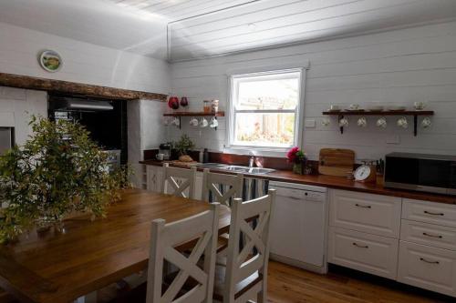 a kitchen with a wooden table and a dining room at Woolbrook Cottage - Charming 1890's Heritage in Taralga