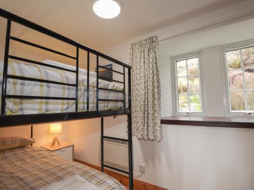 a bedroom with two bunk beds and two windows at Talla Hope in Portree