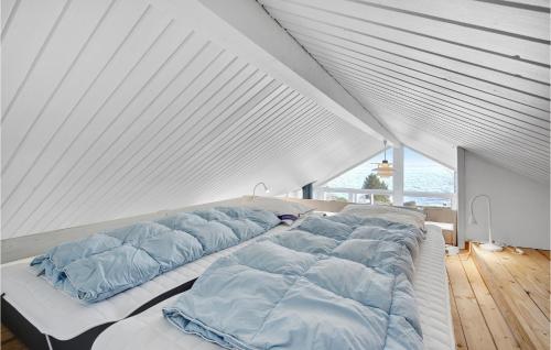 a large white bed with blue pillows on it at Cozy Home In Snekkersten With Kitchen in Snekkersten