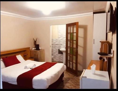 a hotel room with a bed and a television at Starpoint Guest house in Vereeniging