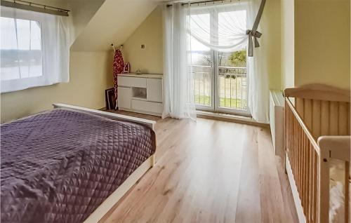 a bedroom with a bed and a large window at Awesome Home In Mragowo With Lake View in Mrągowo