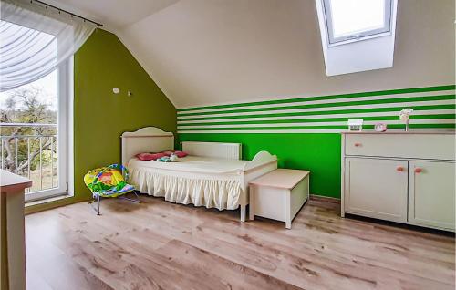 a childs bedroom with green walls and a bed at Awesome Home In Mragowo With Lake View in Mrągowo
