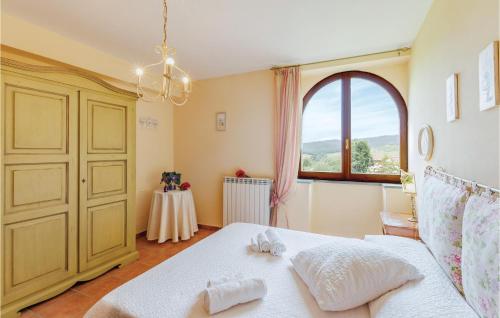 a bedroom with a white bed and a window at Il Gelsomino in Casole dʼElsa