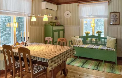 a dining room with a table and a couch at Awesome Home In Forsns With Sauna And 2 Bedrooms 