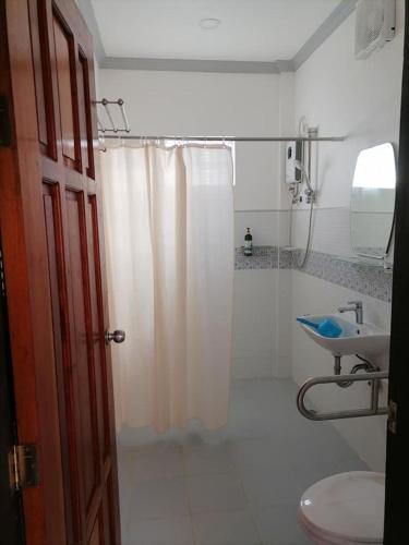 a bathroom with a shower curtain and a sink at La Bella Swiss Inn in San Vicente