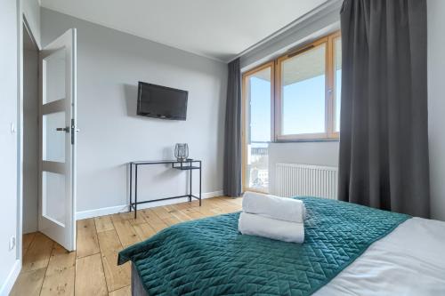シュチェチンにあるEXCLUSIVE Polonia Apartmentsのベッドルーム1室(緑の毛布、窓付)