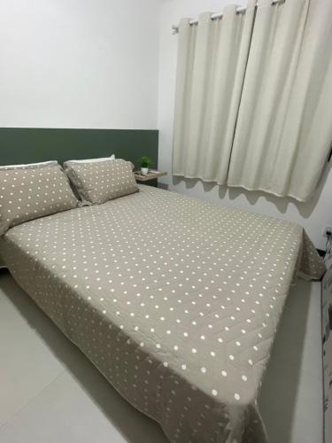 Bett mit Polka-Punkten-Bettwäsche in einem Schlafzimmer in der Unterkunft Apartamento Praia do Forte in Mata de Sao Joao