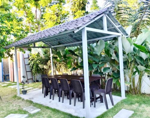 a wooden table and chairs under a pergola at Casa LeoMa in Cavite