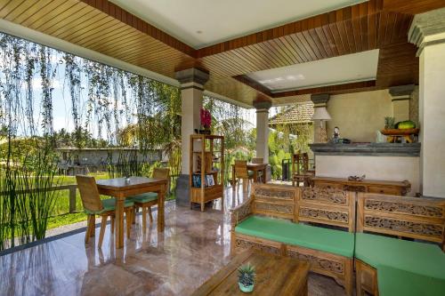 a living room with wooden furniture and a large window at Cahaya Ubud Villa in Ubud