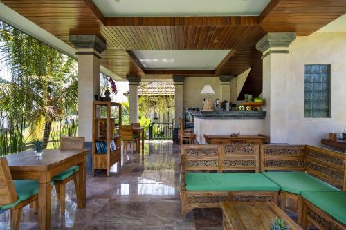 an outdoor patio with wooden furniture and a bar at Cahaya Ubud Villa in Ubud