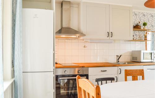 a kitchen with white cabinets and a white refrigerator at Awesome Home In Vrena With Wifi in Vrena