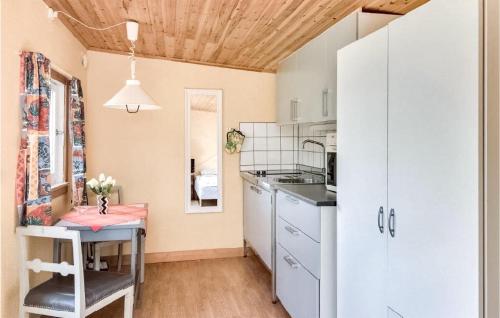 a kitchen with white cabinets and a table with flowers on it at Skomaker Stuga in Visby