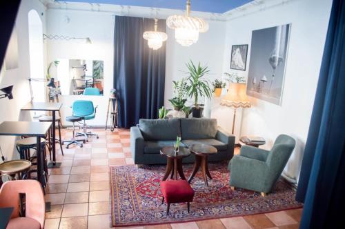 ein Wohnzimmer mit einem Sofa, Stühlen und einem Tisch in der Unterkunft Hostel Jamaika in Vilnius