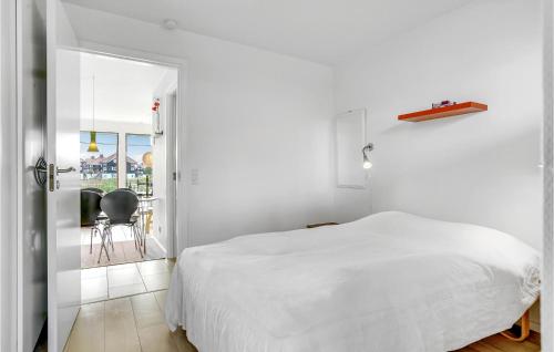 a white bedroom with a bed and a balcony at 2 Bedroom Gorgeous Apartment In Bogense in Bogense