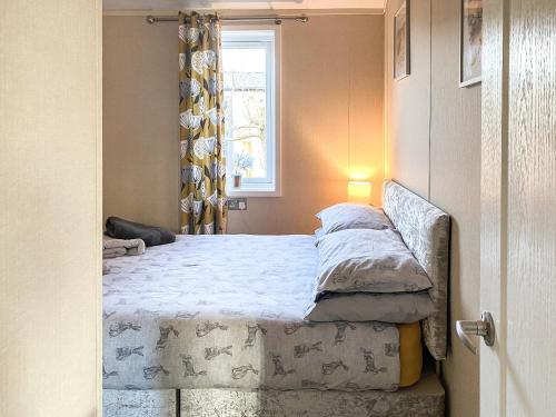 a bed in a bedroom with a window at Gingerbread Lodge in Wilberfoss