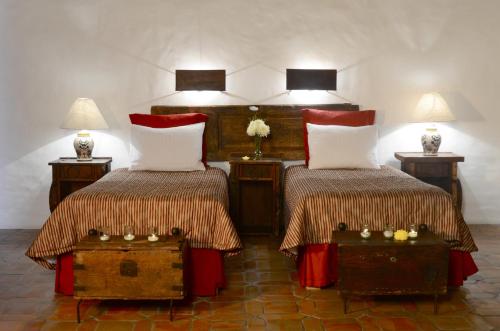 a bedroom with two beds and two tables with lamps at Villas Danza del Sol in Ajijic